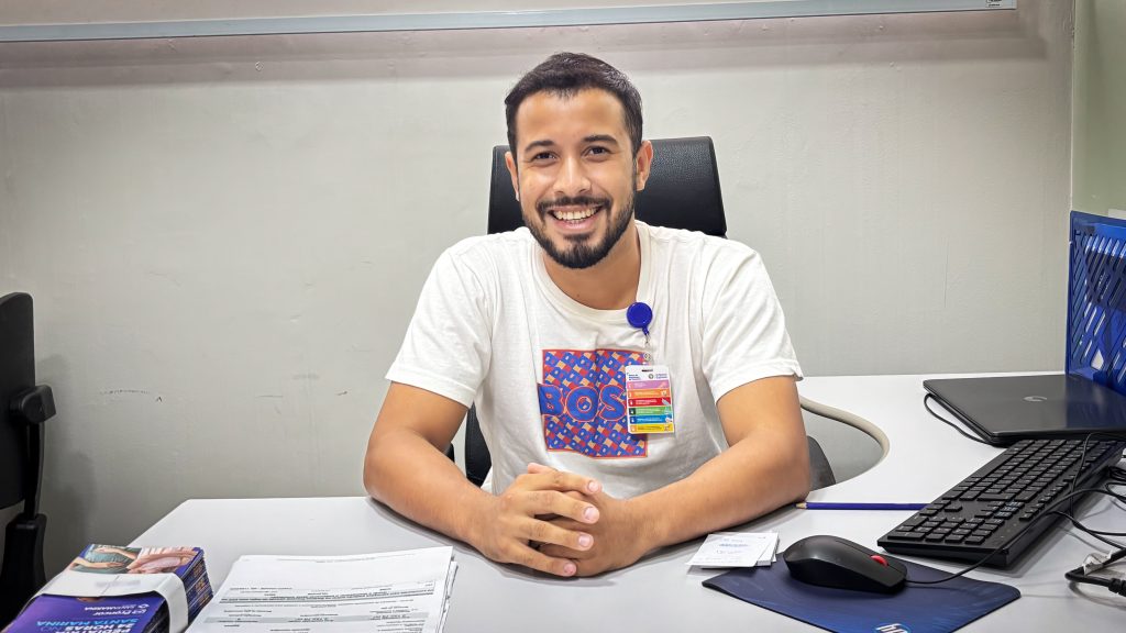 Eurer Eduardo, um homem sorrindo, olhando para frente.