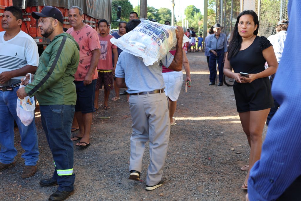 Indígena carrega cestas de alimentos