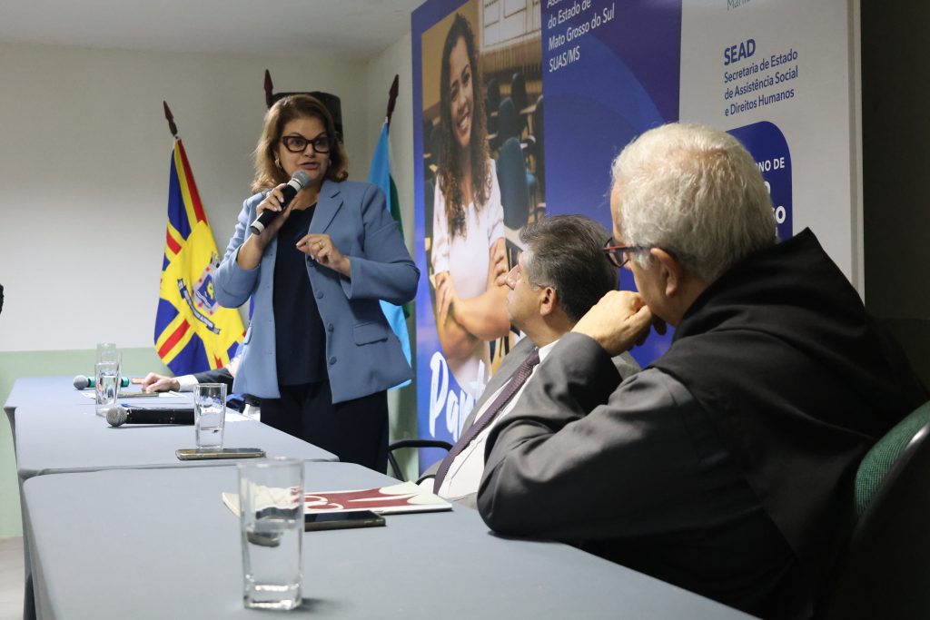 Secretária PAtrícia Cozzolino fala e membros da mesa prestam atenção.
